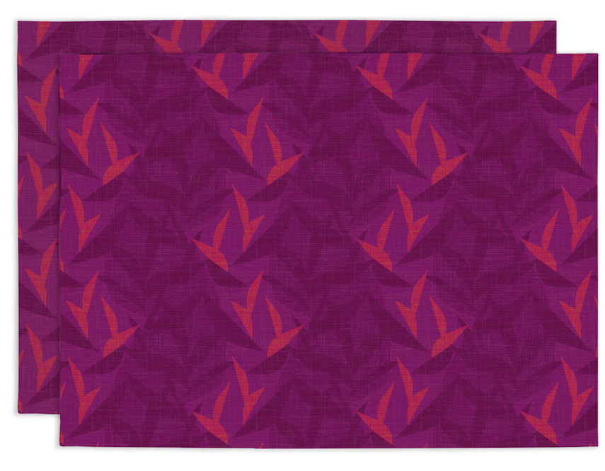 Two purple placemats with red geometric Lele Mahalo pattern on a matching background