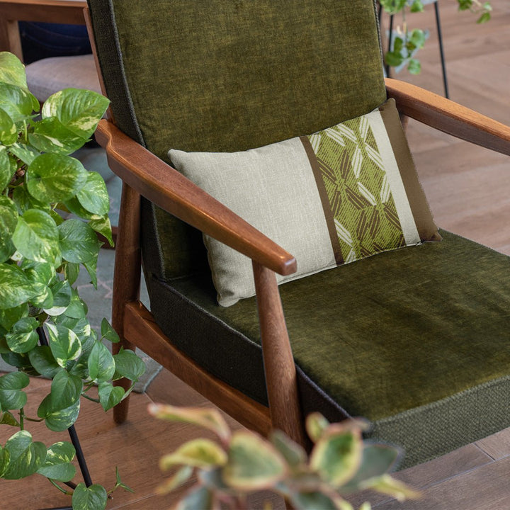 Moss & Brown Peʻa Stripe Lumbar Pillowcase on an olive chair