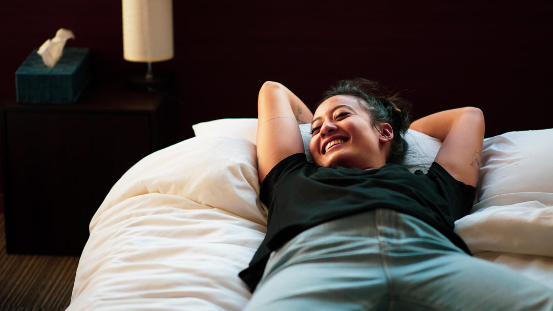 A woman in a happy mood relaxing on a comfortable bed