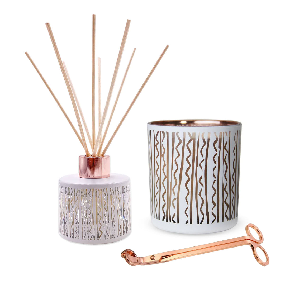 puakenikeni scented diffuser and candle plus rose gold wick trimmer on white background