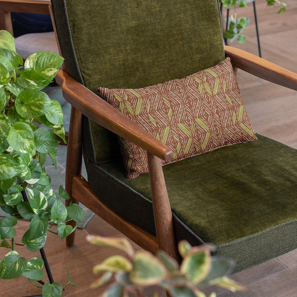 Chartreuse & Cocoa 'Akahi Lumbar Pillowcase placed in a chair with a potted plant on the side as an accent