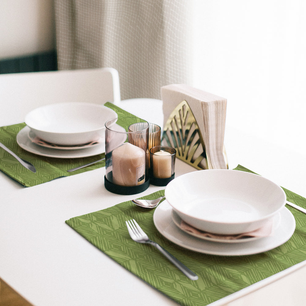 A table set with the 'Akahi Dining Placemat Set in Green  with  white plates and bowls set atop them, creating a clean and modern dining arrangement.