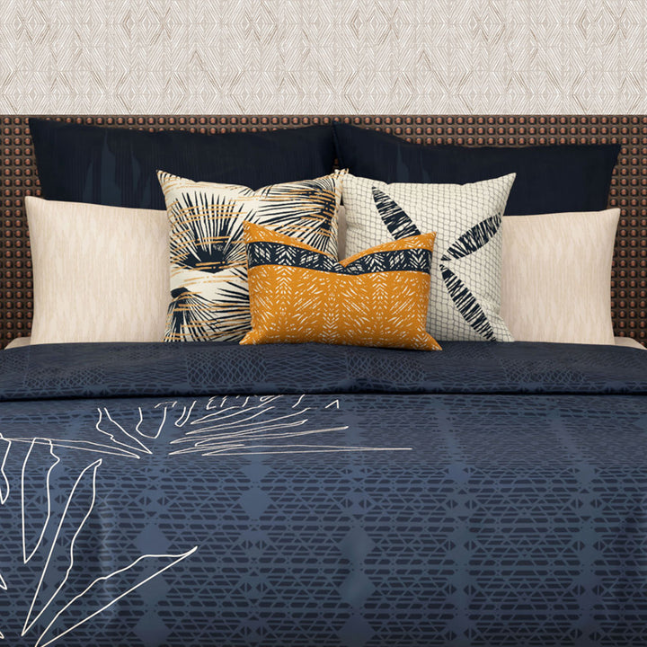 Close-up of Hōʻolu Hiamoe Comforter In Dark Blue On a King Size Bed With Orange and Hawaiian Print Decor Pillows