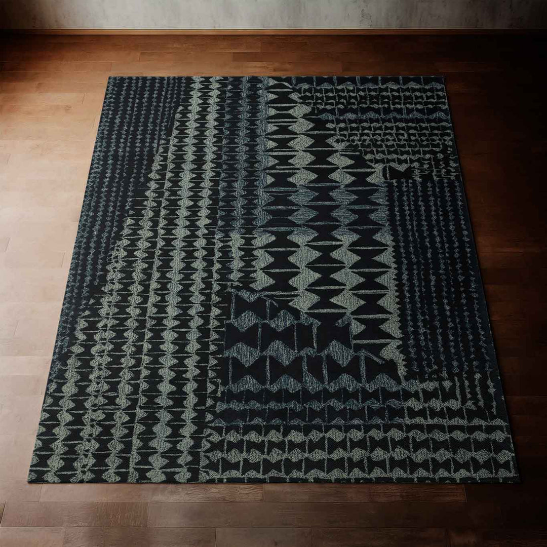 Rich Charcoal Color Kāpili Hawaiian Area Rug Laid Out Flat on a Hardwood Floor