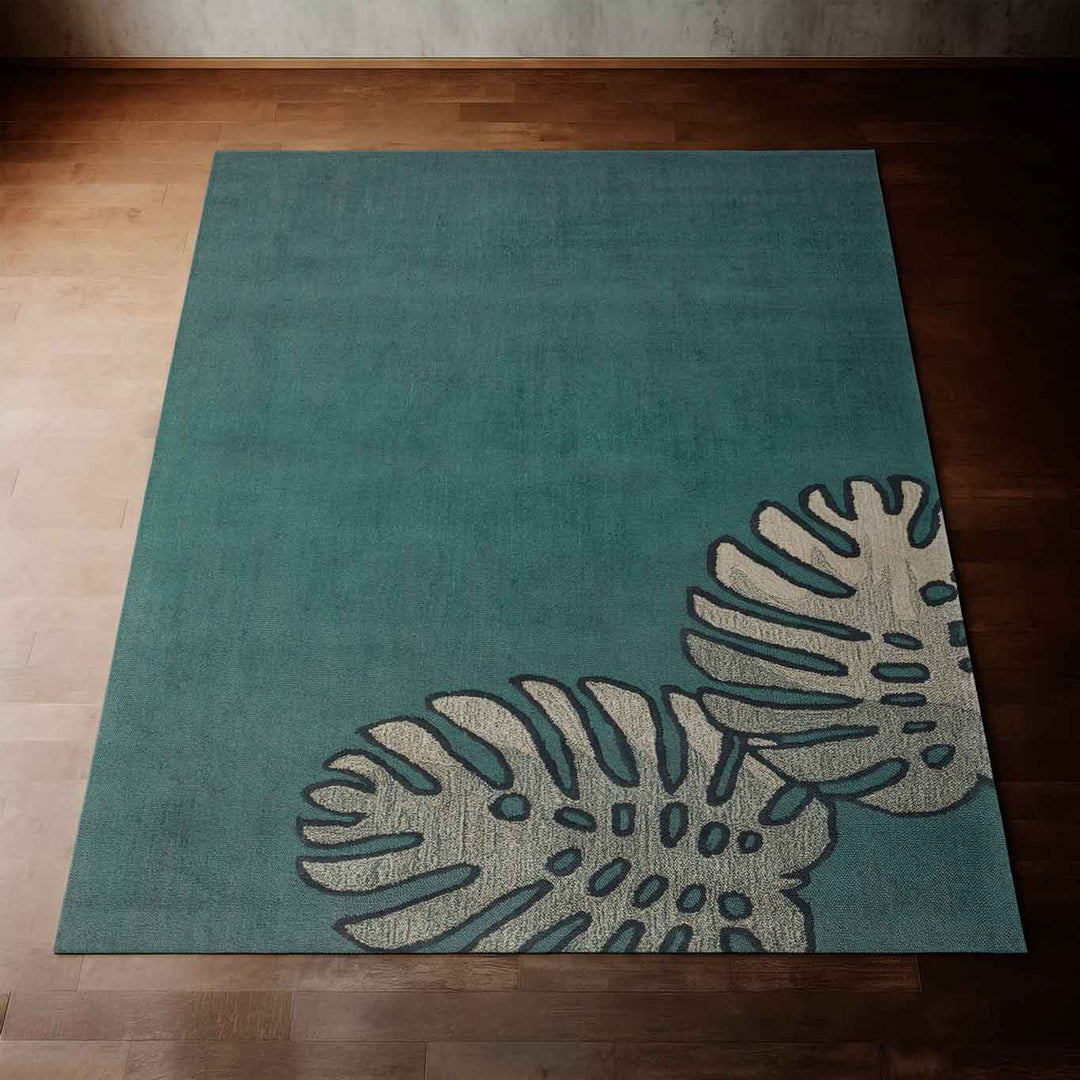 Beautiful Teal Monstera Coastal Area Rug Laying Flat on a Hardwood Floor