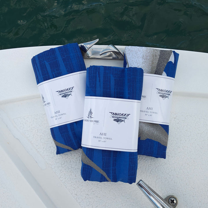 three wrapped blue microfiber travel towels on boat with ahi fish print