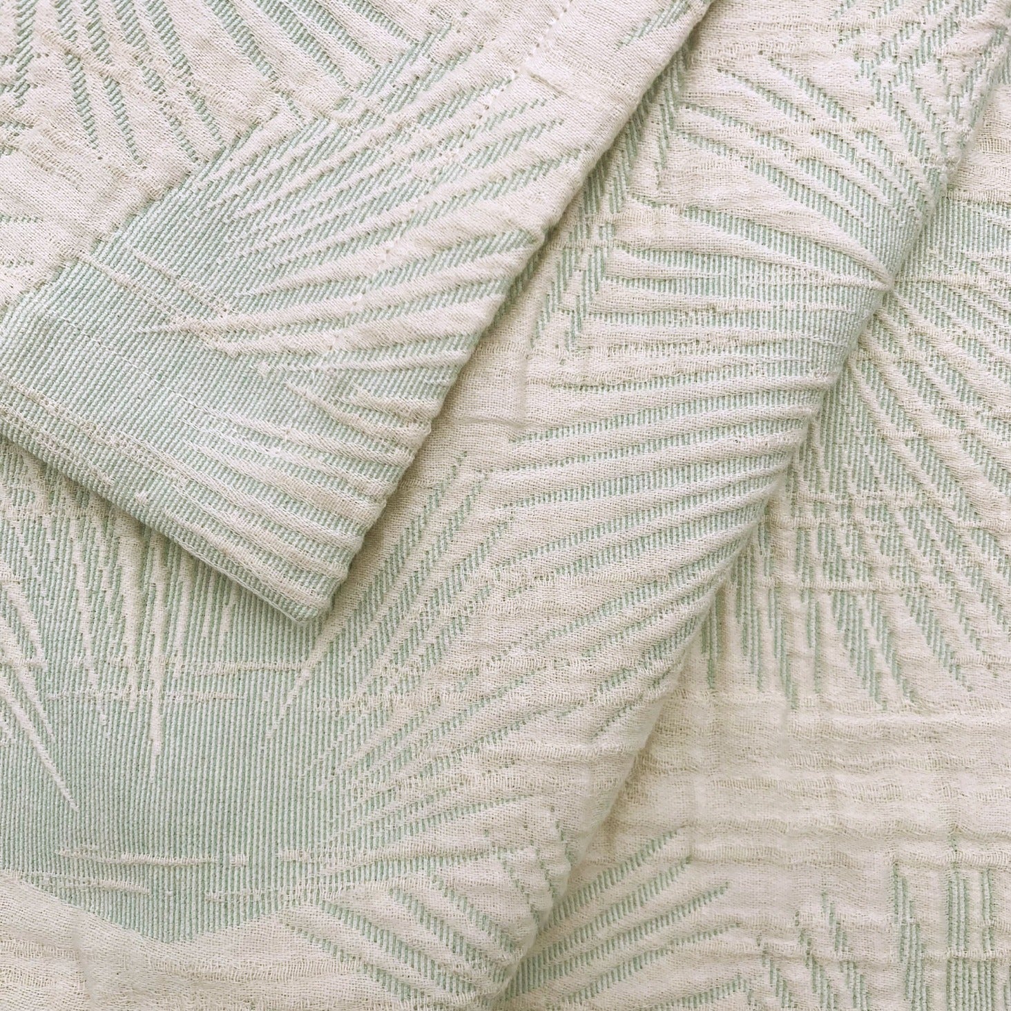 Loulu green coverlet with fan palm pattern.  
