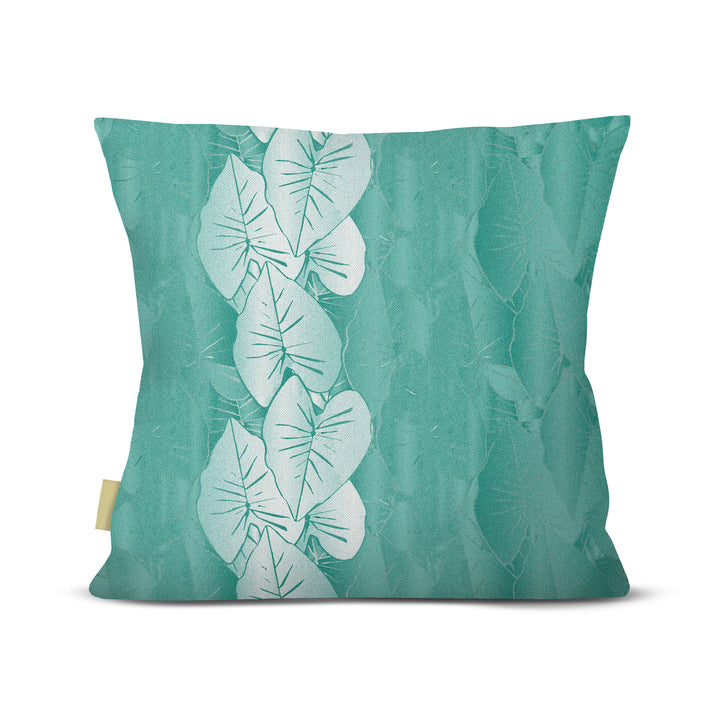 Teal pillow with white kalo leaf pattern on a white background