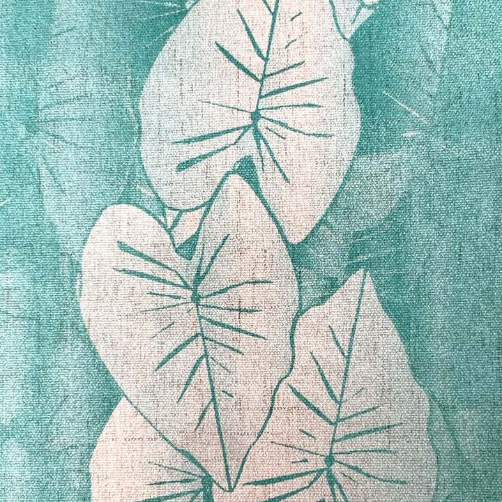 Textured fabric with white leaf pattern on a teal background.