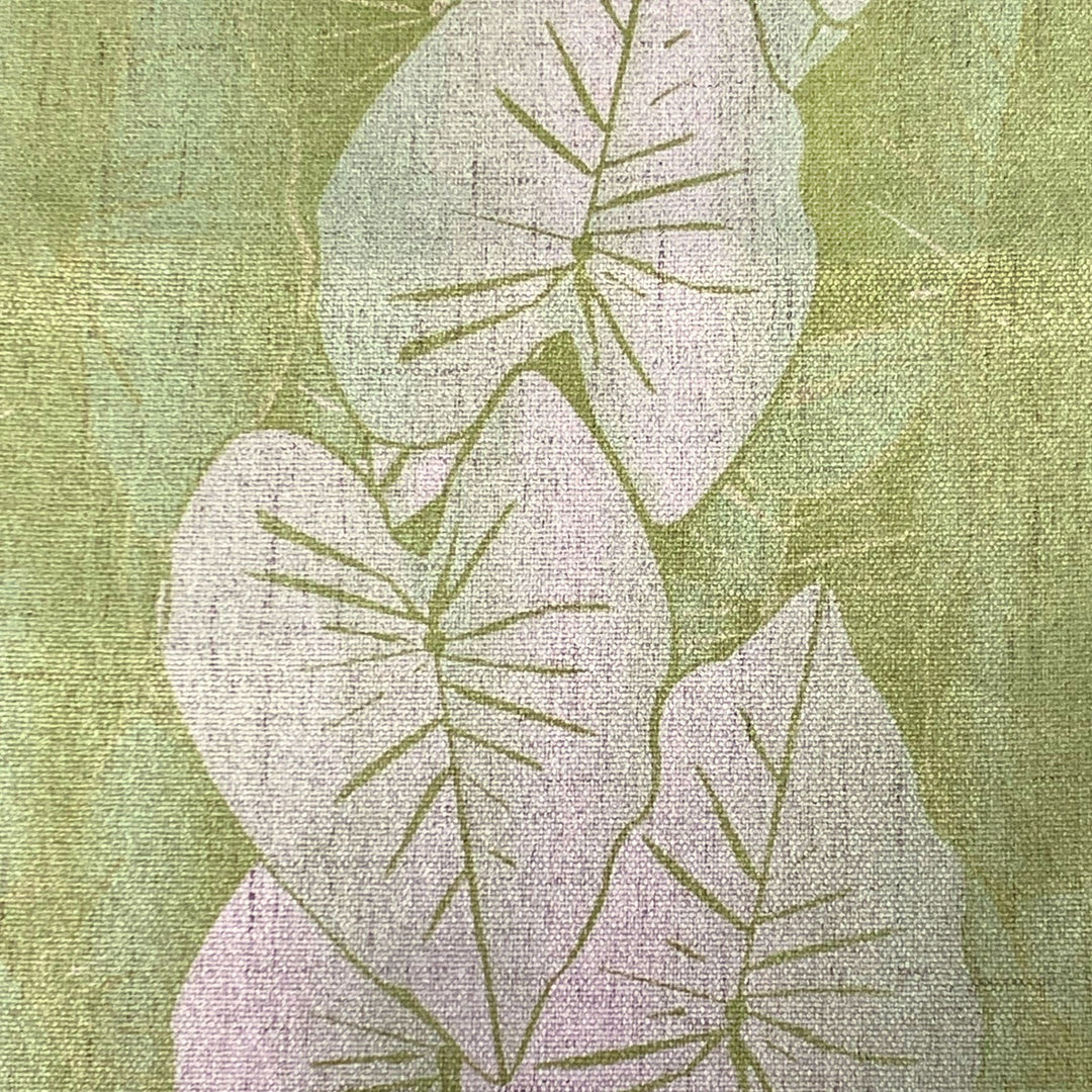 Textured fabric with white kalo leaf pattern on a green background