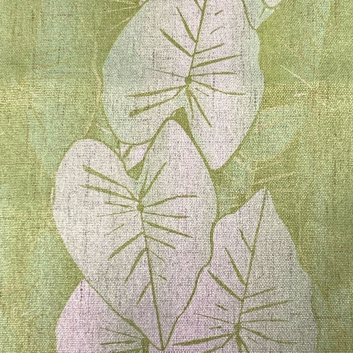 Textured fabric with white kalo leaf pattern on a green background