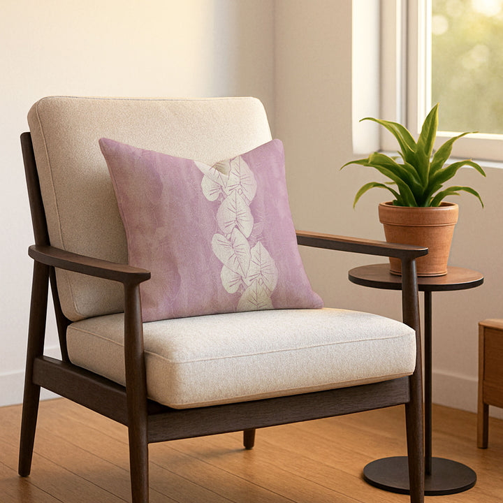 Beige armchair with a lavender pillow and a small table with a plant in a room.