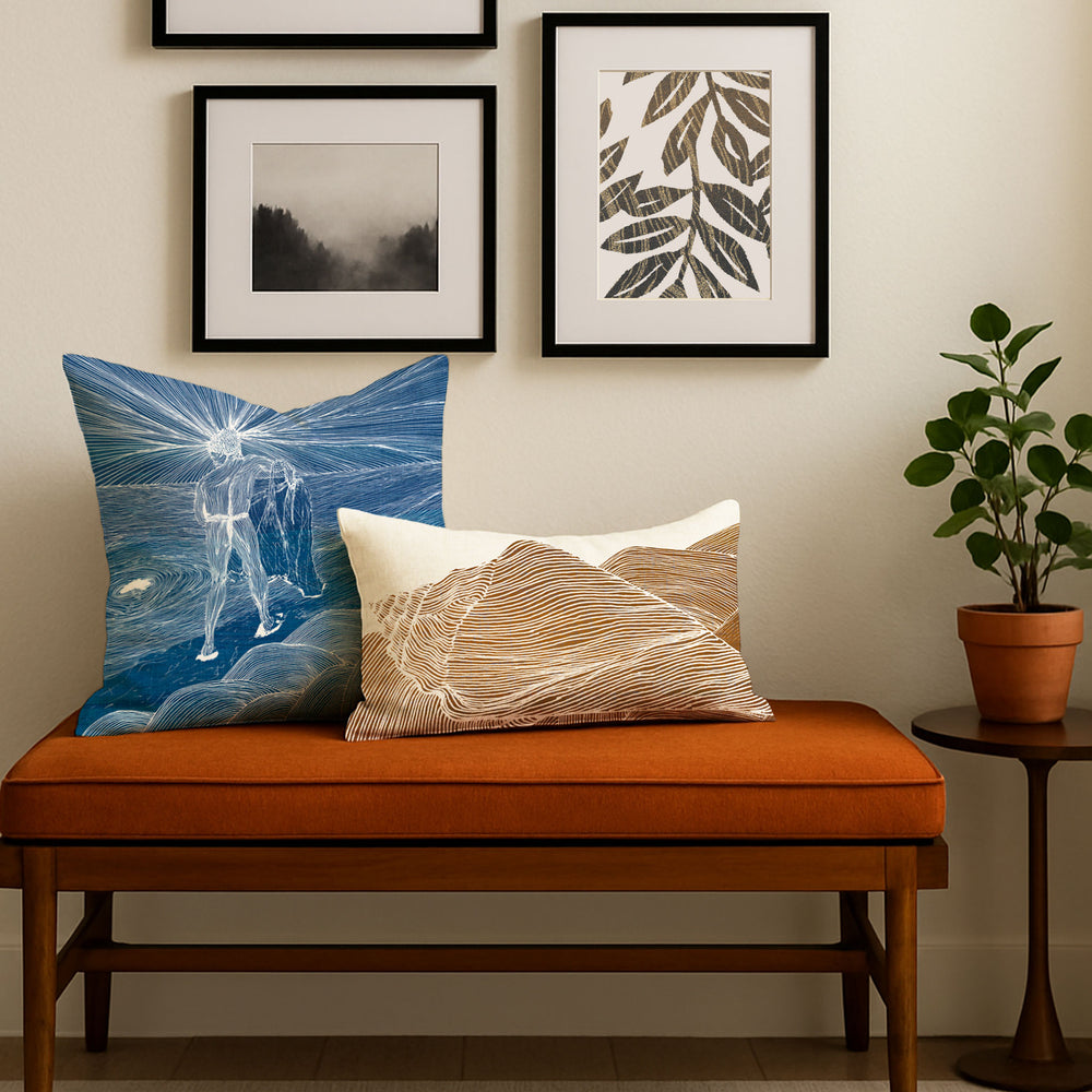 Decorative pillows on an orange bench with framed artwork on the wall.