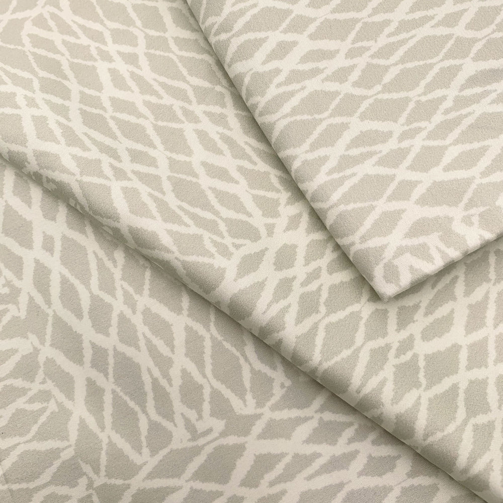 Close view of the white ʻUpena fishnet print on a NOHO HOME bed pillowcase