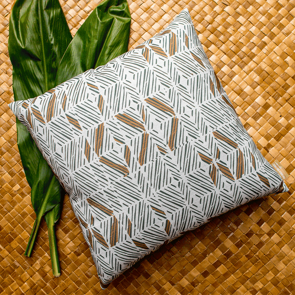 Bark Stone and Ivory ʻAkahi Square Pillowcase Set On a Woven Mat With Tea Leaves Next to It