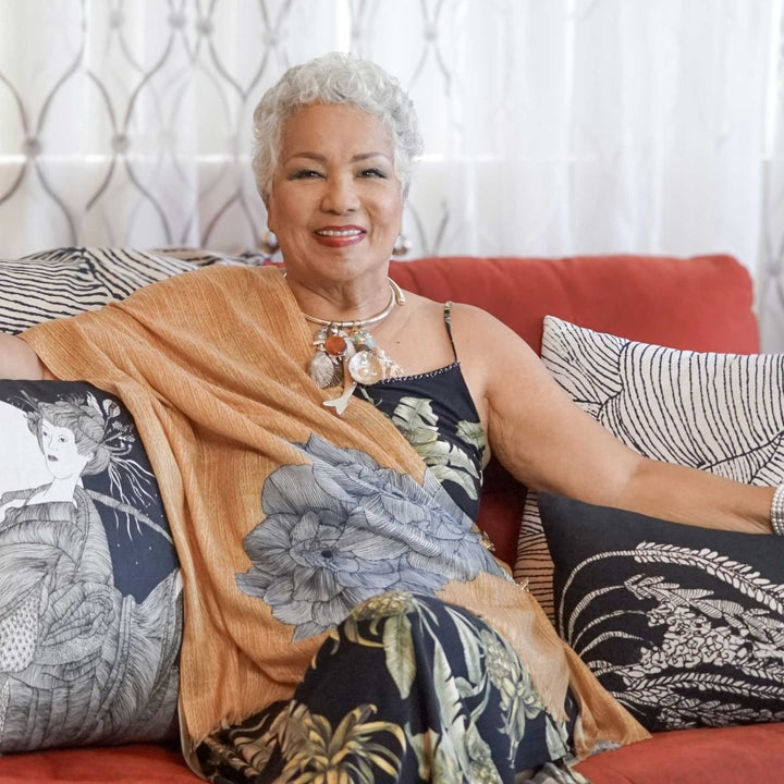 Hawaiian Artist Melveen Leed Sitting on a Couch With Pillows Around Her