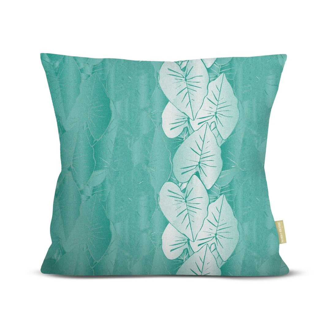Teal pillow with white kalo leaf pattern on a white background.