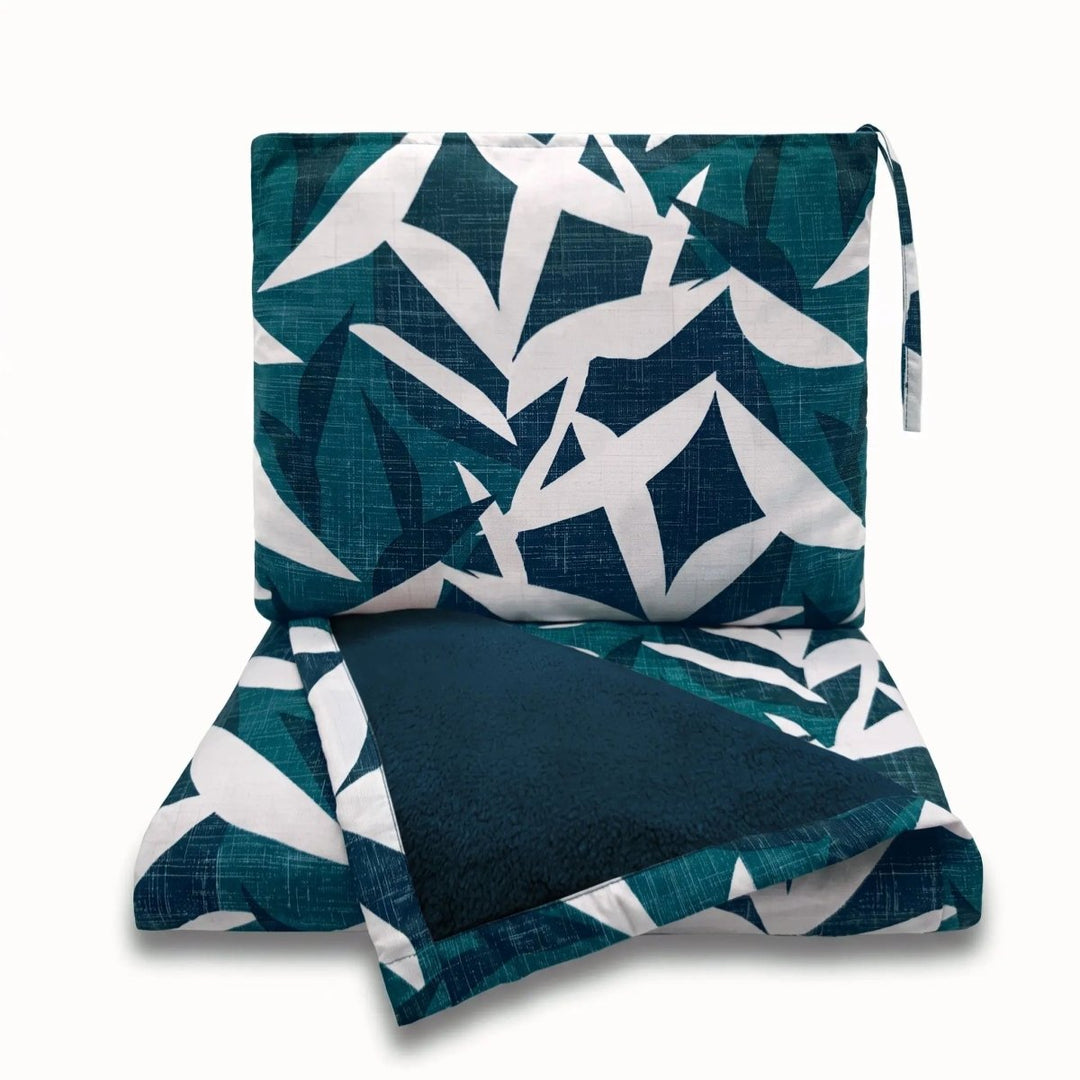 Lele Travel Blanket in Twilight, folded into its wristlet — Native Hawaiian ʻiwa bird pattern by NOHO HOME.