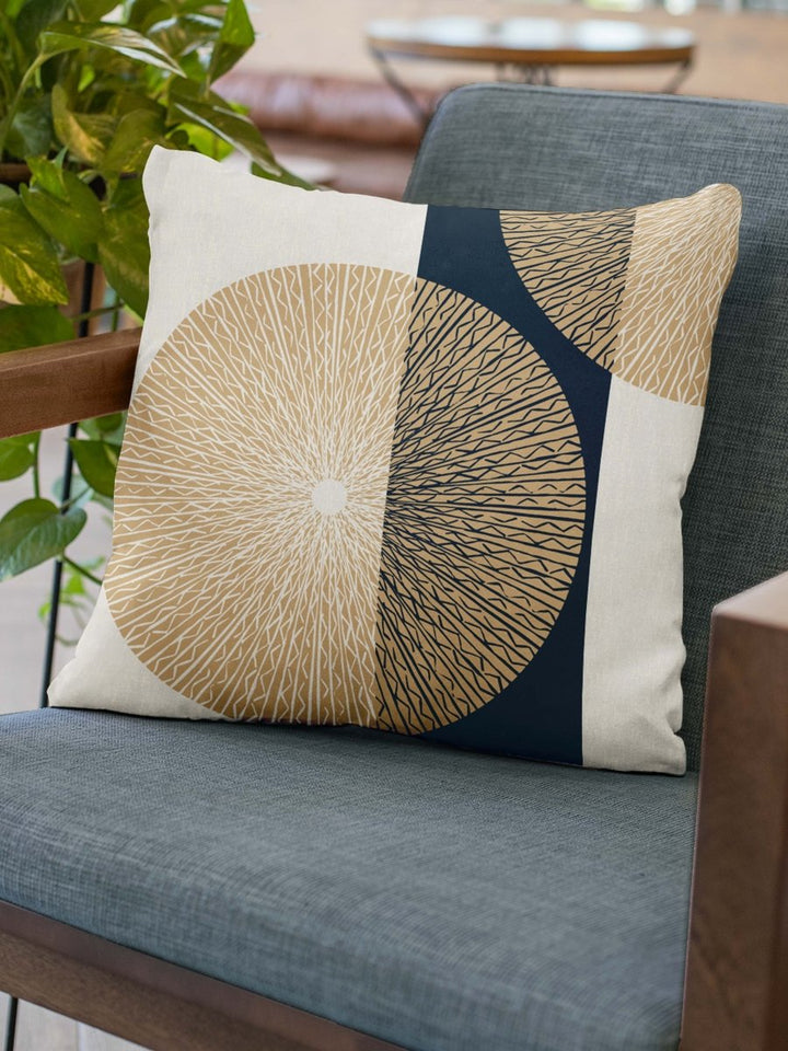 Pine & Cranberry Niho Medallion Square Pillow on grey chair with plant on the side