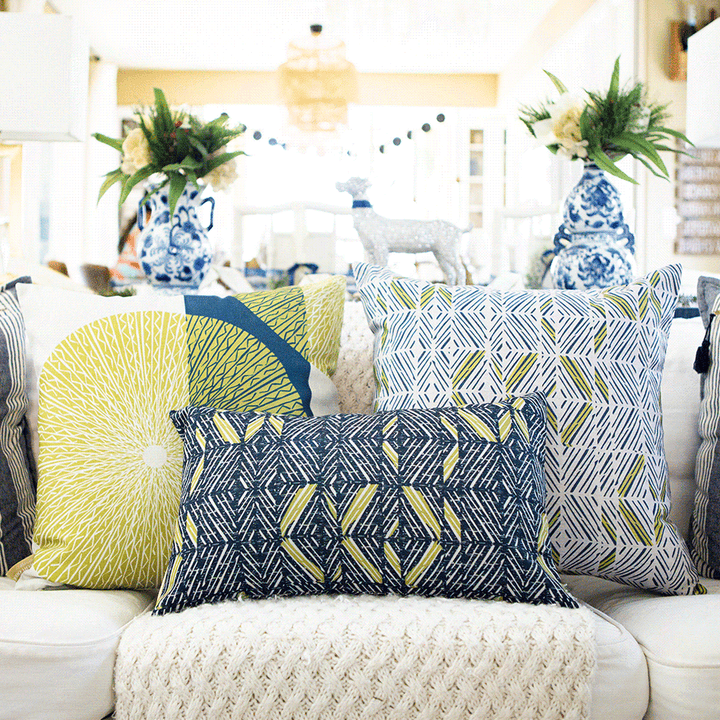 Moss & Navy Niho Medallion Square Pillow on an ivory sofa, paired with ʻAkahi Square and Lumbar pillows of the same color scheme