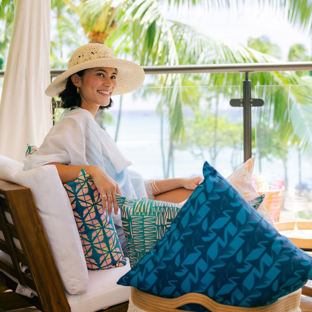 Woman sitting on a patio with palm trees in the background