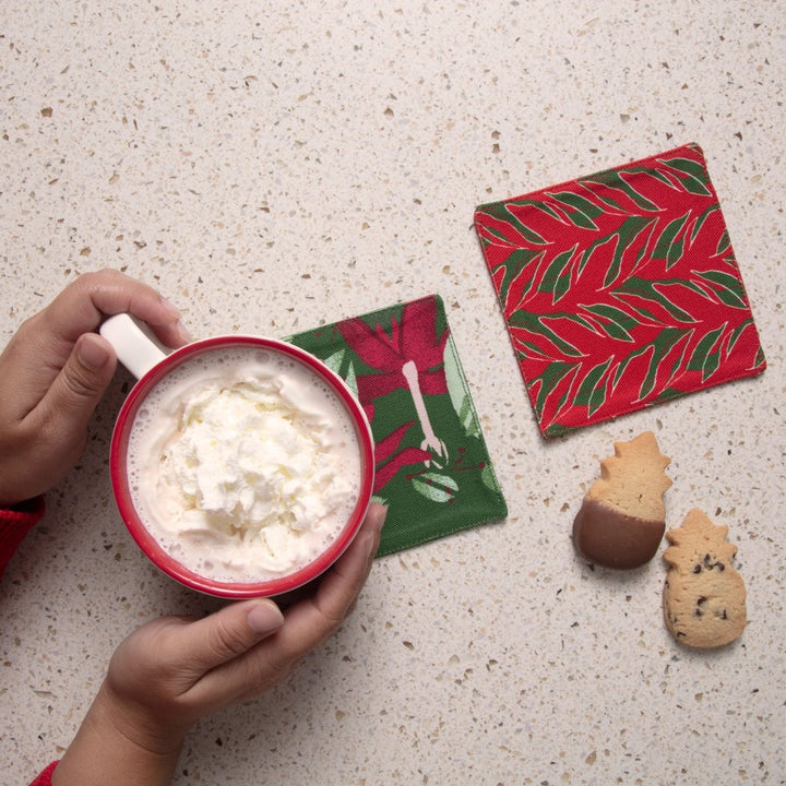 Kī and Kokiʻo ʻUlaʻula coasters beside a mug of cocoa and Honolulu Cookie Company shortbread