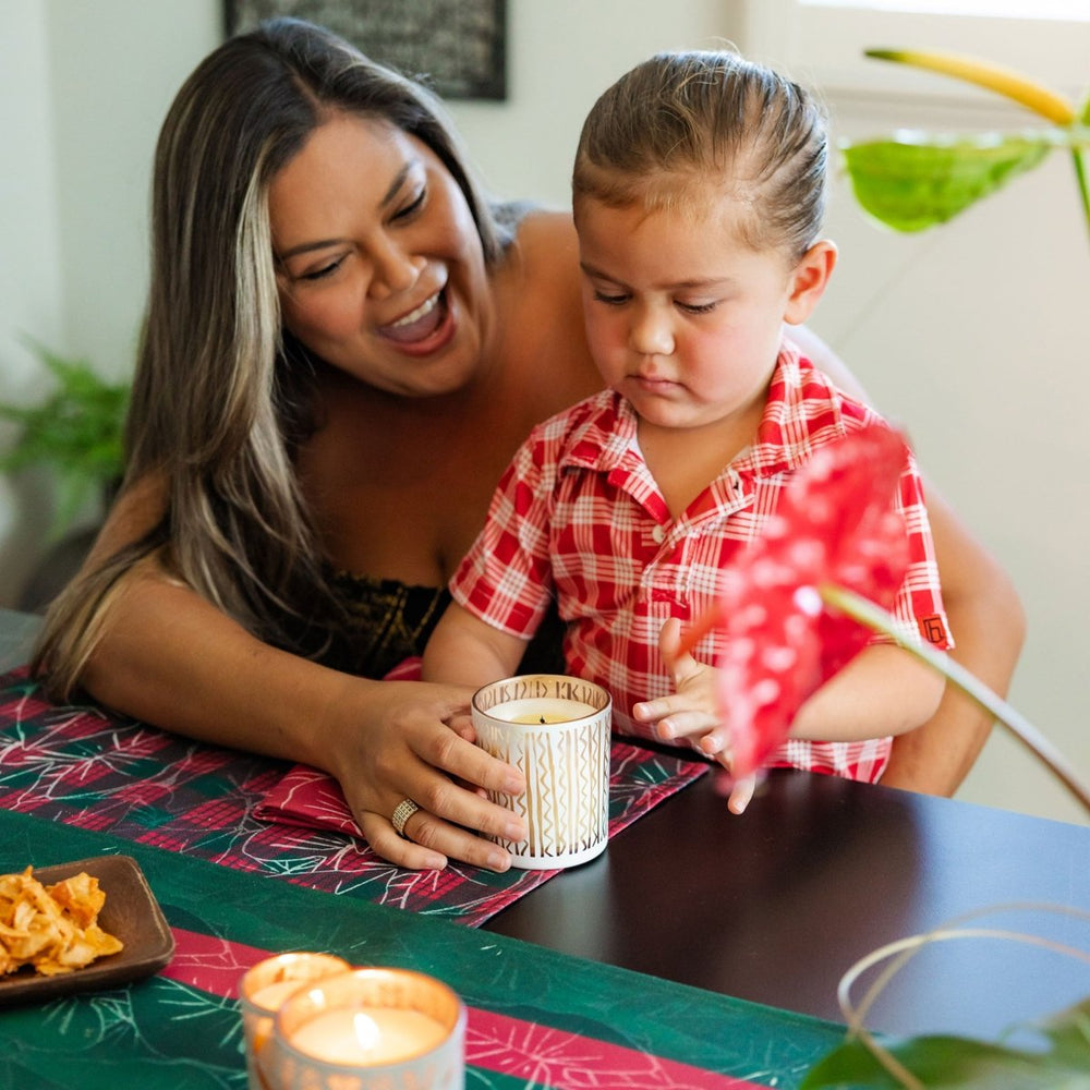 Woman and child at a table with candles and snacks, smiling.