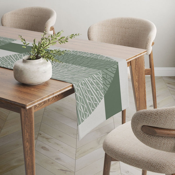 Sage Niho Medallion table runner adorned on wooden table.