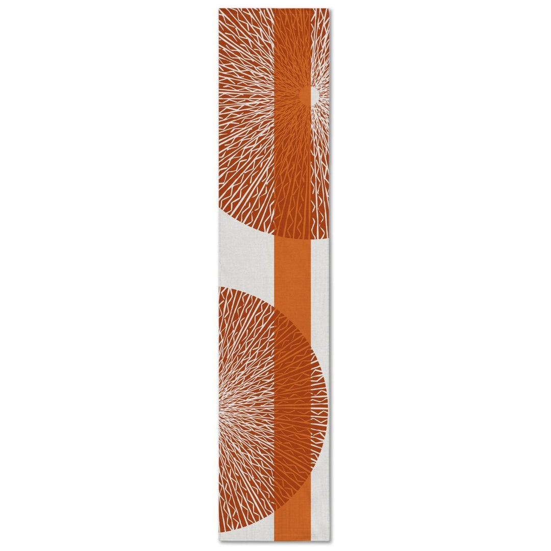 A rectangular table runner with a white background and an orange niho medallion pattern.