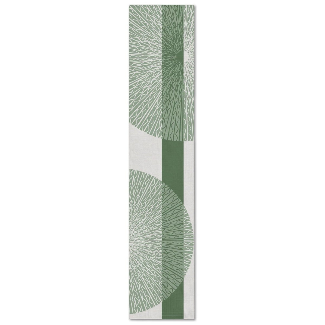 A rectangular table runner with a white background and a sage niho medallion pattern.