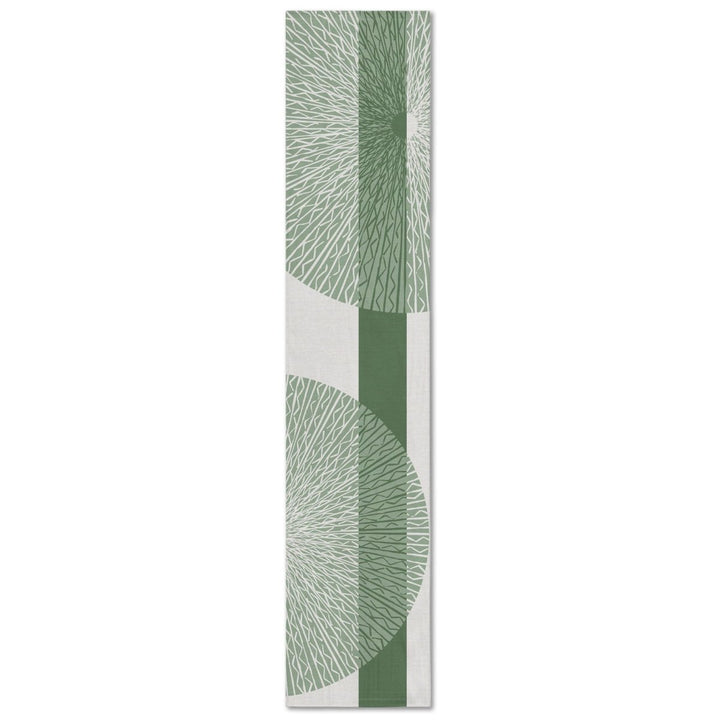 A rectangular table runner with a white background and a sage niho medallion pattern.