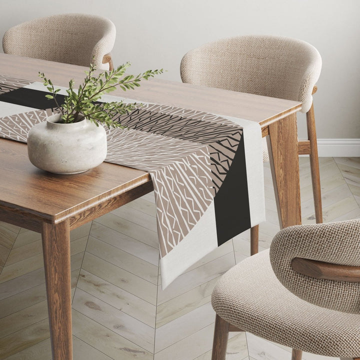 Black Niho Medallion table runner adorned on wooden table.
