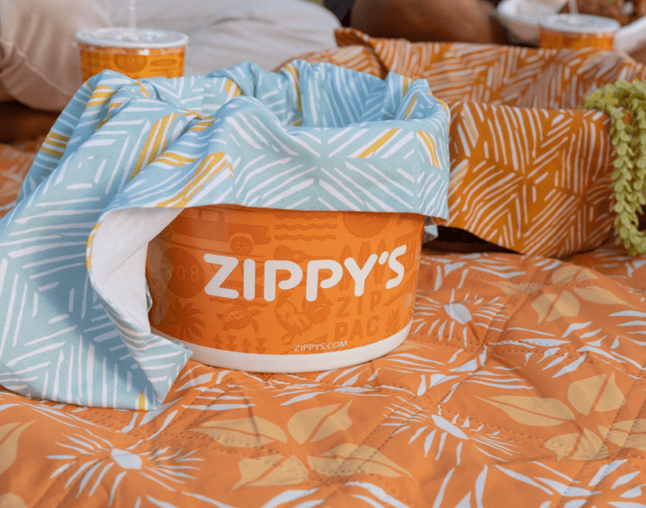 Zippy's chili bucket with a patterned cover on a colorful blanket