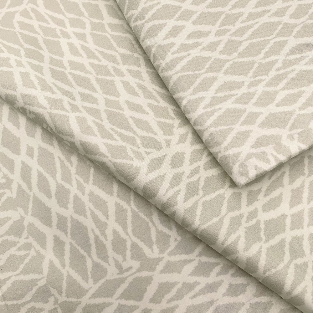 Close view of the white ʻUpena fishnet print on a NOHO HOME bed pillowcase