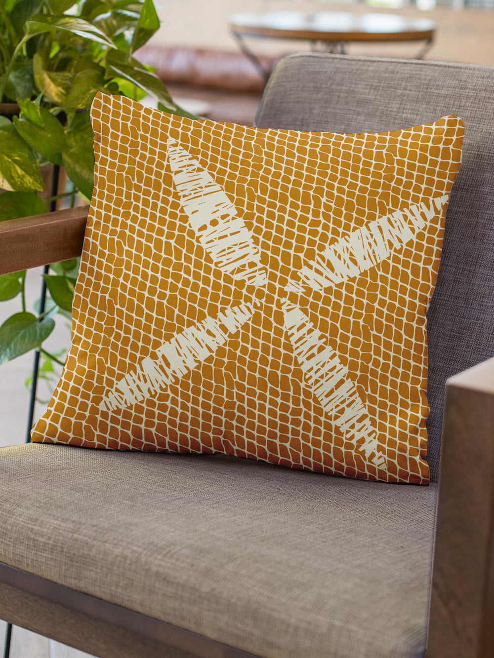 Turmeric Kapua Kai Square Pillowcase Set On a Grey Chair With Wooden Arms