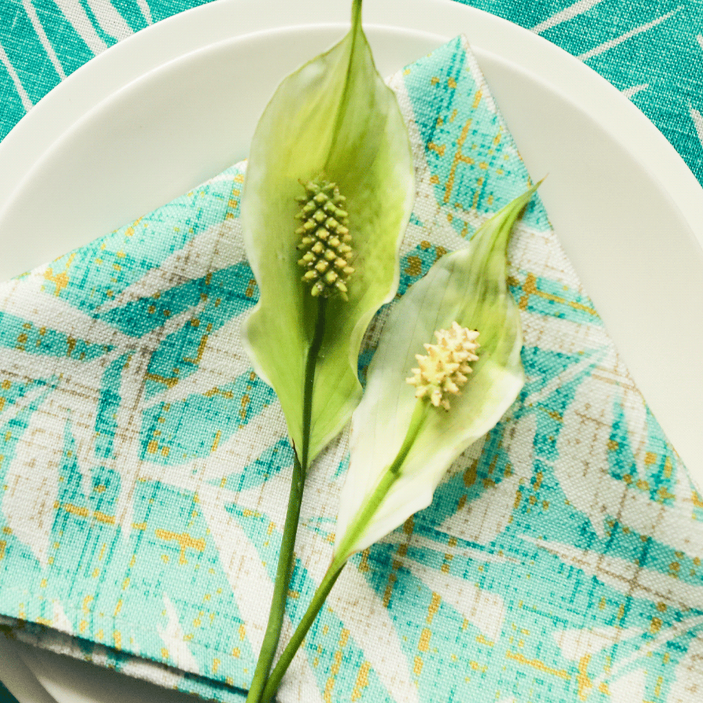 Lauaʻe Dining Napkin Set On a White Plate With a Flower On Top Of It