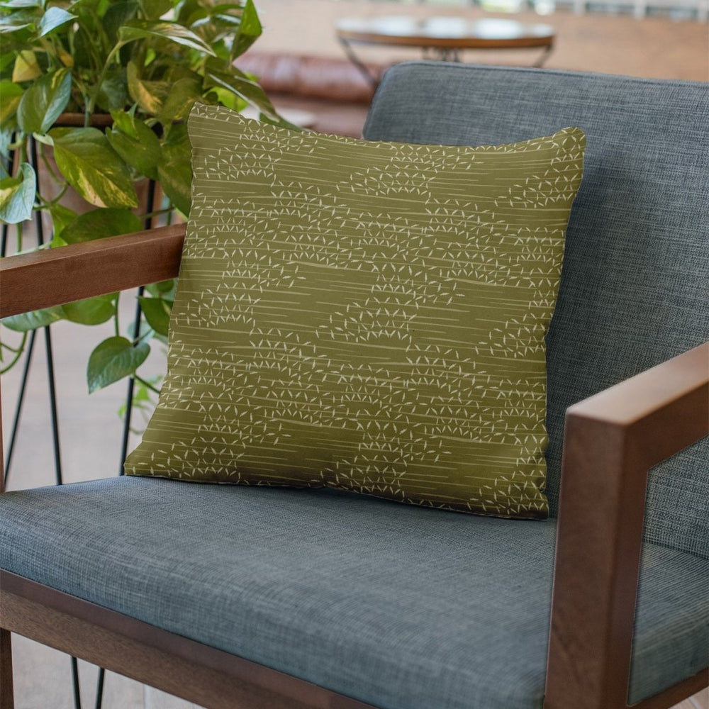 Olive and Ivory Kaha Square Pillowcase Set On a Teal Blue Chair With Wood Arms