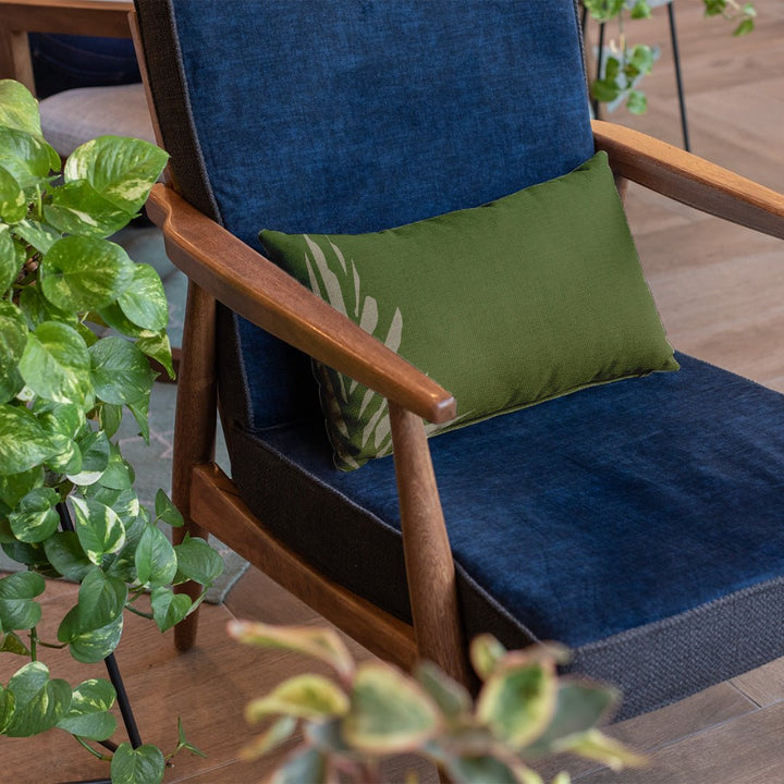 Green & Ivory Kanu Lumbar Pillowcase on a dark blue chair with plants on the side