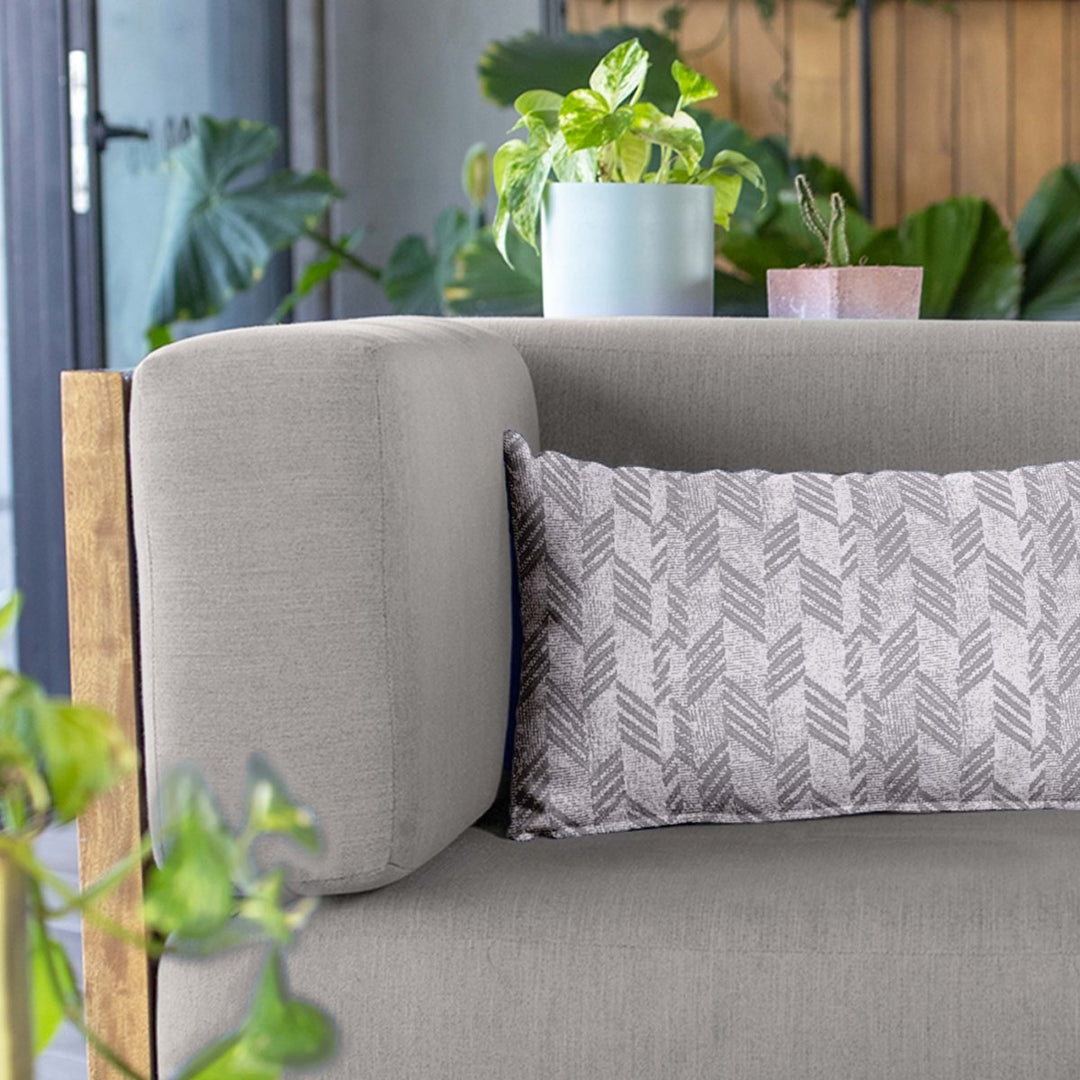 Ash Kapa Hou Lumbar Pillowcase on a grey sofa with a variety of plants in the background