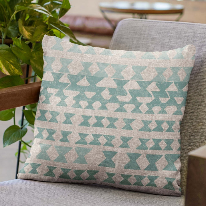 Multicolor Kāpili Square Pillowcase Placed On a Grey Fabric Chair With Wooden Arms