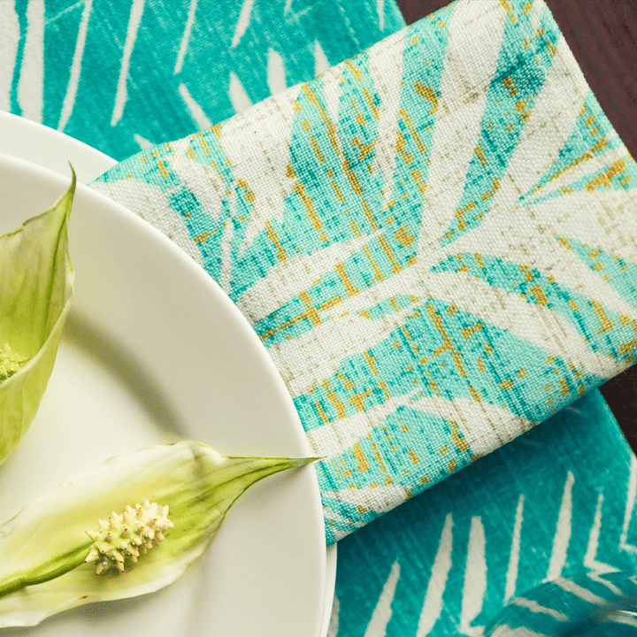 Lauaʻe Dining Napkin Folded and Set Under the Rights Side of a White Plate