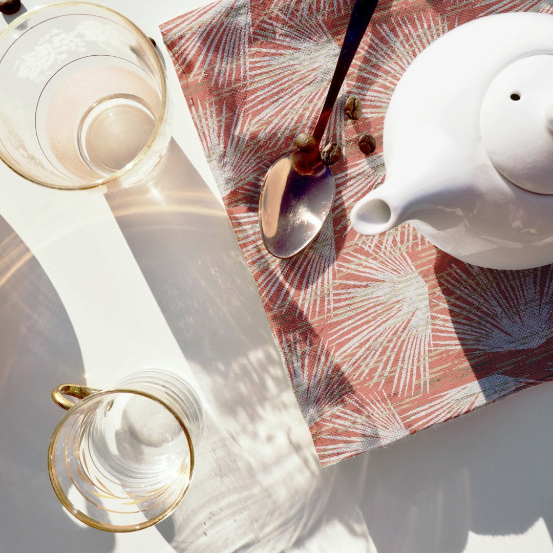 Teapot and spoon resting on Ivory and Red Loulu Dining Napkin Set