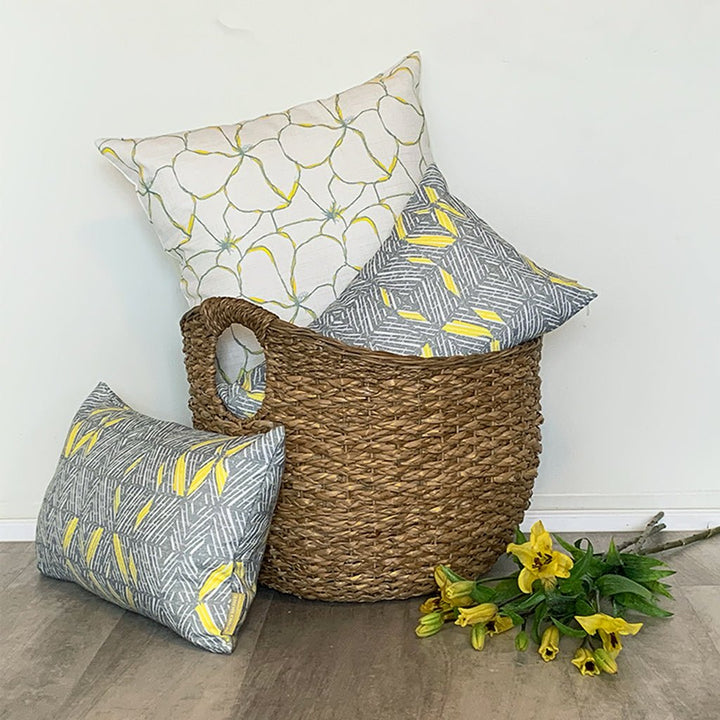 Mōhala Square Pillowcase Sitting Inside a Wicker Basket With Décor Pillows Around It