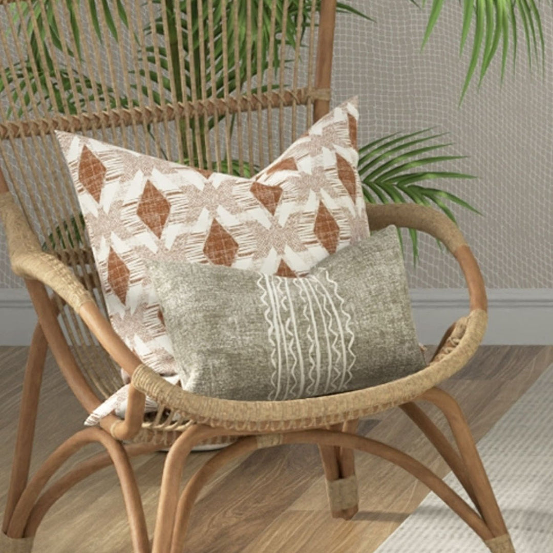 Niho Lumbar Pillowcase Set On a Wicker Chair With a Square Pillow Behind It
