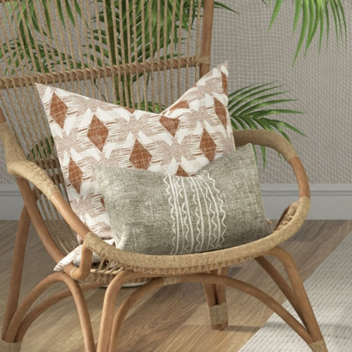 Niho Lumbar Pillowcase Set On a Wicker Chair With a Square Pillow Behind It