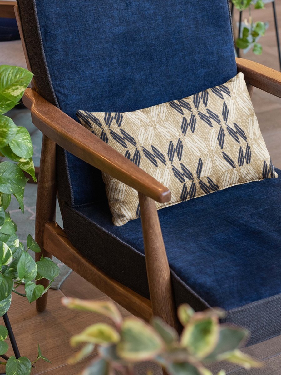 Sand & Midnight Peʻa Lumbar Pillowcase on a navy chair