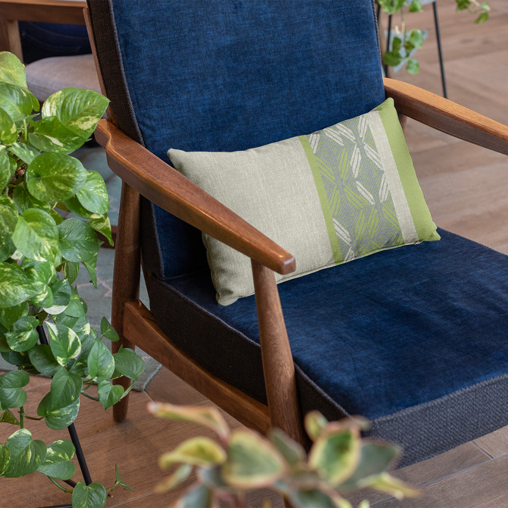 Celery & Light Blue Peʻa Stripe Lumbar Pillowcase on a navy chair