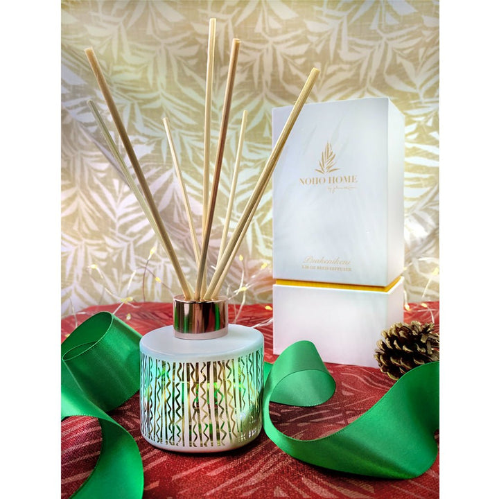 Puakenikeni Reed Diffuser and  its box with green ribbon and pine cone accent